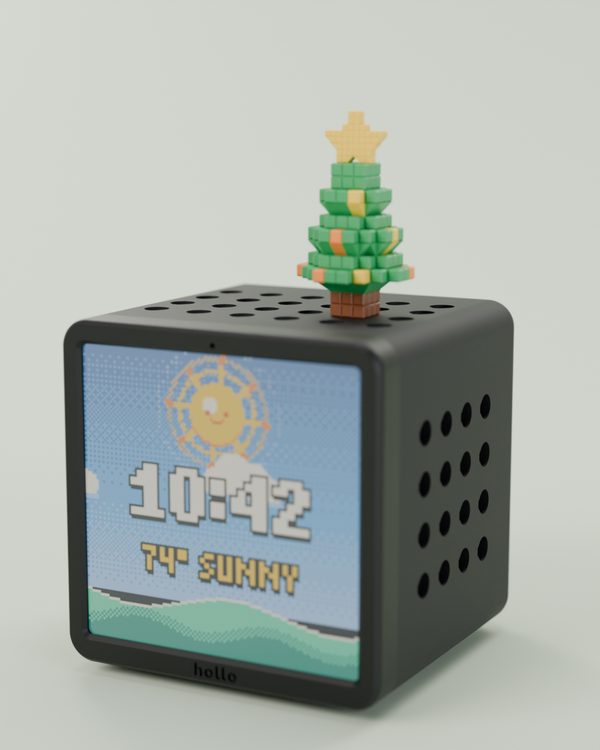 Rendered studio shot: a black Hollo with a small pixel holiday tree with a gold star, showing the clock and sunny weather